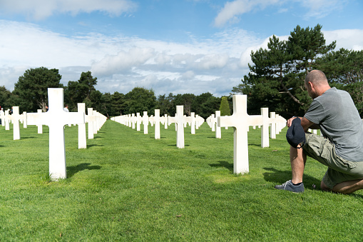 Colleville-sur-Mer, Calvados, Normandy / France - 16 August 2019:  middle-aged man remembering his fallen grandfather at the American Cemetery in Omaha Beach