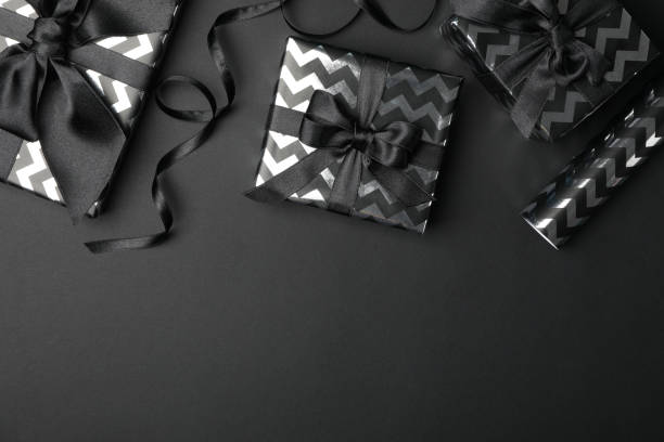 istock Gift boxes with bow on black background. Black Friday sale 1184401513