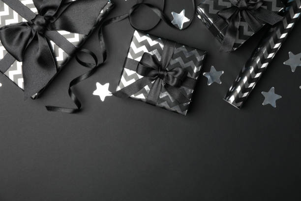 istock Gift boxes with bow on black background. Black Friday sale 1184401575