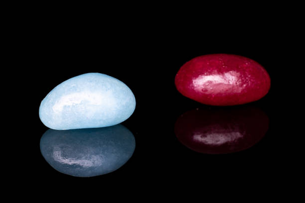 istock Jelly bean candy isolated on black glass 1184401767