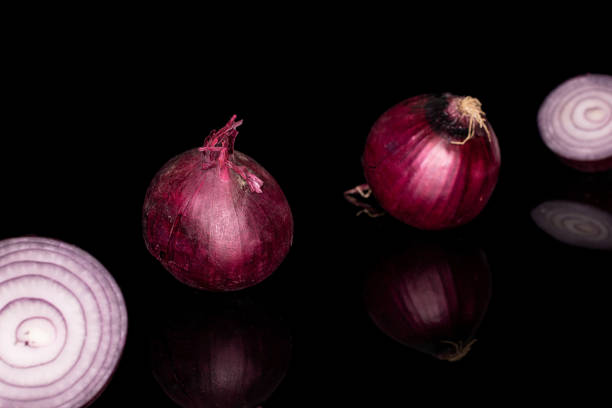 istock Fresh red onion isolated on black glass 1184402514