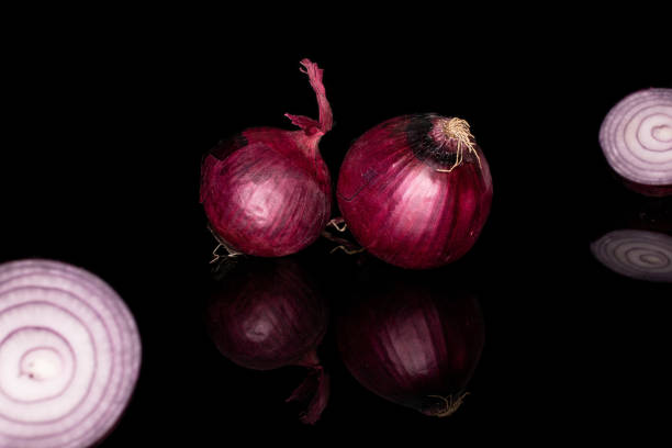 istock Fresh red onion isolated on black glass 1184402524