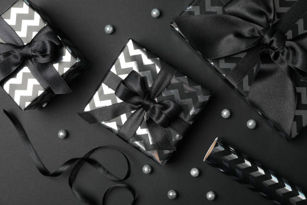 istock Gift boxes with bow on black background. Black Friday sale 1184403001