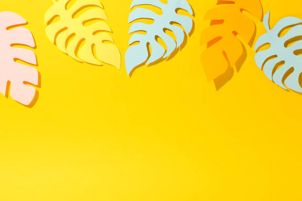 istock Tropical papercraft palm leaves on yellow background, space for text 1184403138