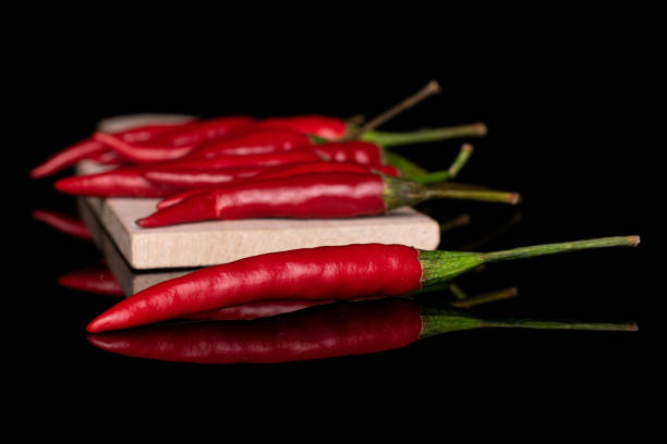 istock Hot bird's eye chili isolated on black glass 1184404133