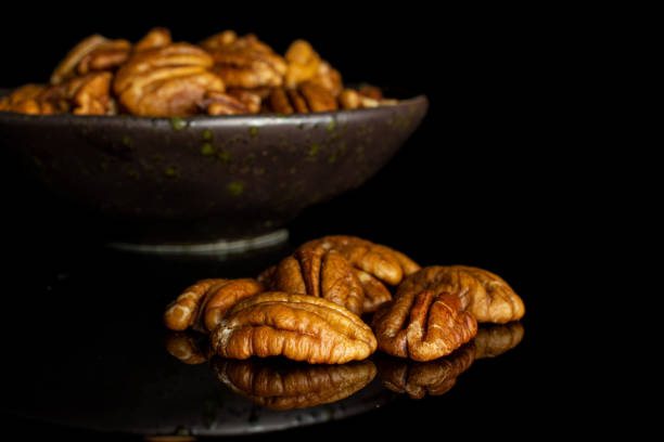 istock Dry brown pecan nut isolated on black glass 1184406130