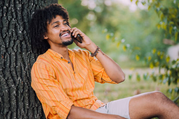 istock Young Afro man talking on the phone outdoors 1184406568