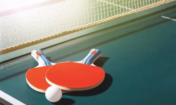 Table Tennis Rackets and Ball on Table with Net
