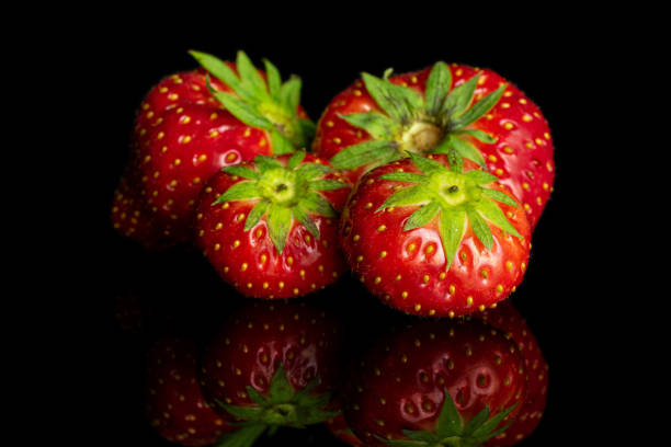 istock Fresh red strawberry isolated on black glass 1184409529