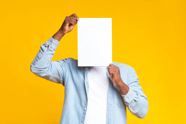 negro que se cubre la cara con papel blanco en blanco - black sign holding vertical fotografías e imágenes de stock