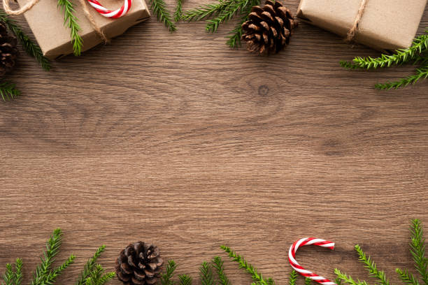 istock Wood table with Christmas decoration including gift boxes, candy cane, pine branches and pine cones. Merry Christmas and happy new year concept. Top view with copy space, flat lay. 1184409771
