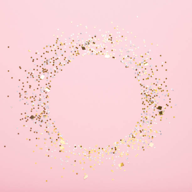 Round copy space of gold confetti on pink background