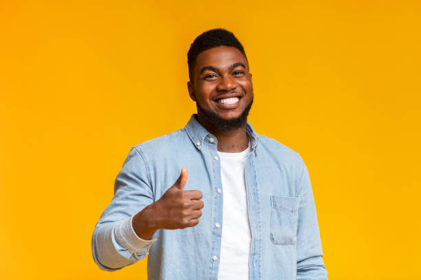 istock Smiling african american man showing thumb up at camera 1184409855