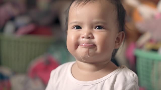 Baby girl blowing saliva and smiling