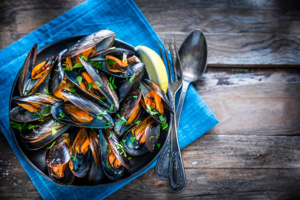 istock Steamed mussels on rustic wooden table 1184412349