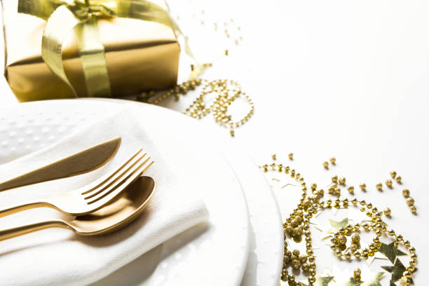 istock Christmas table setting with golden decor and light on white. 1184412743
