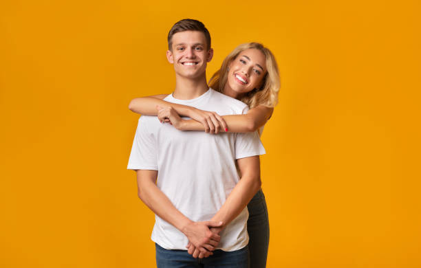 istock Young romantic couple embracing on yellow background 1184414226