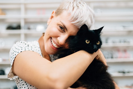 Woman hugs cat in bicycle shop