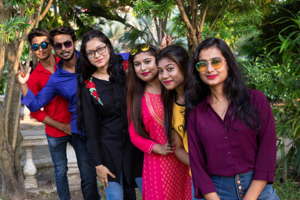 istock Group of cheerful Indian friends standing in a queue 1184415920