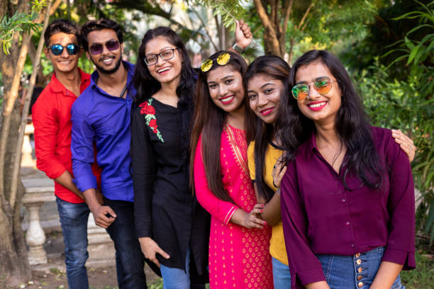 istock Group of cheerful Indian friends standing in a queue 1184416118