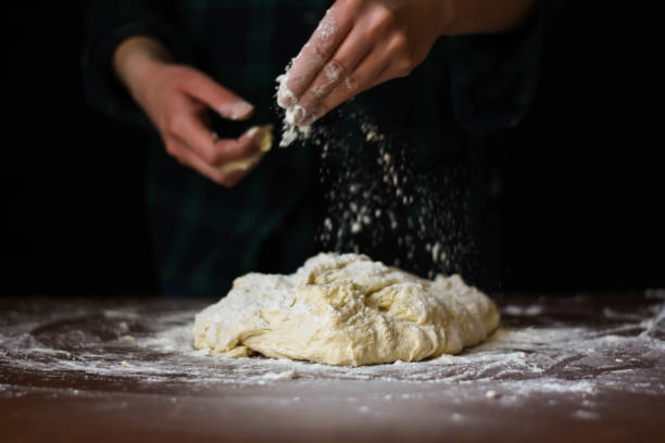 istock female preparing buns at table in bakery 1184416179