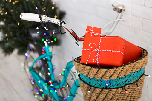Close up of New Year bicycle with pine tree and lights over white background, blurred background