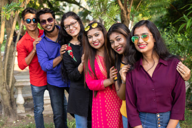 istock Group of cheerful Indian friends standing in a queue 1184416294
