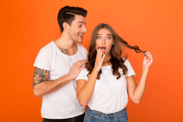istock Millennial guy whispering gossips into girlfriend's ear 1184417466