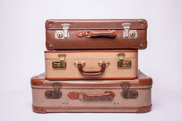 Old, retro, suitcases lie on the table with white background. Obsolete suitcase isolated on white background