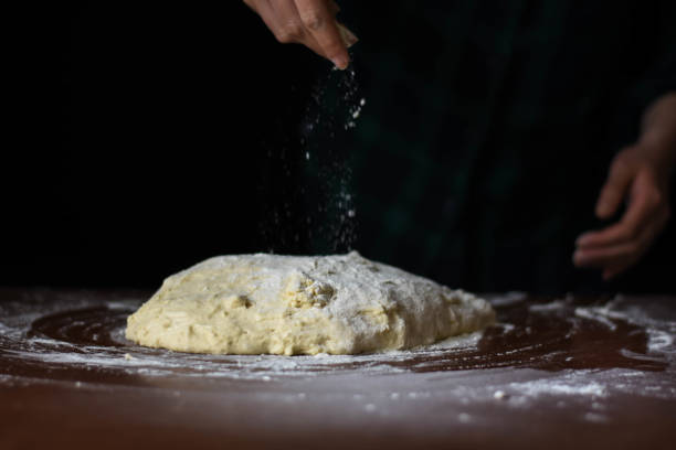 istock female preparing buns at table in bakery 1184417857