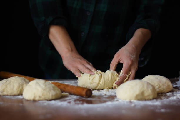istock female preparing buns at table in bakery 1184417860
