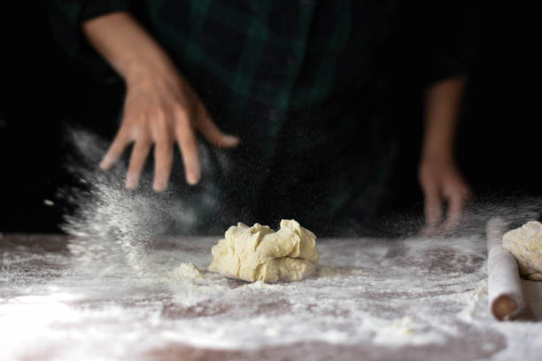 istock female preparing buns at table in bakery 1184417884