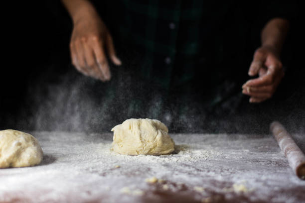istock female preparing buns at table in bakery 1184417889