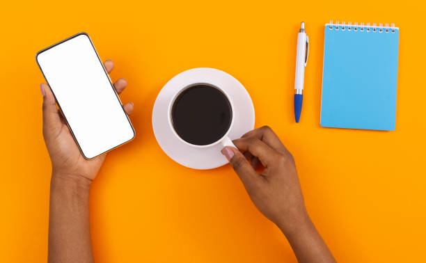 istock Female hands holding smartphone with blank screen and coffee cup 1184417978