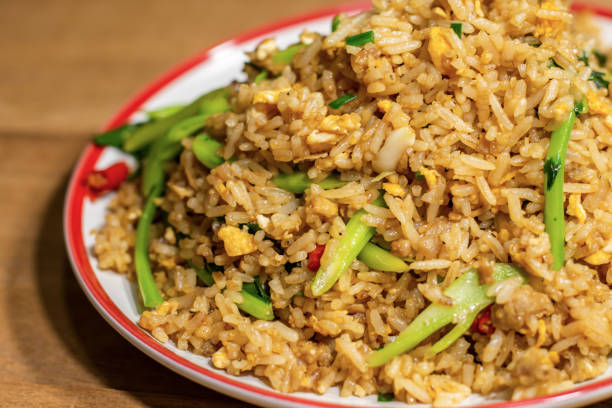 istock Fried rice mix with egg and vegetable in white and red dish on wooden table. 1184417984
