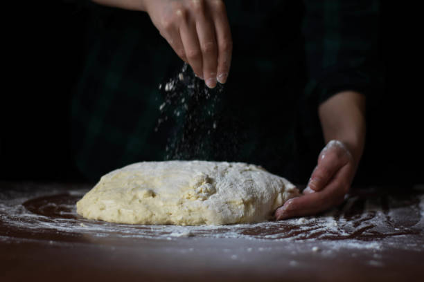 istock female preparing buns at table in bakery 1184418589