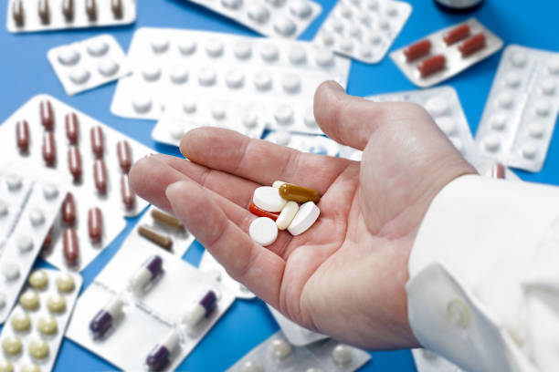 istock Closeup of a man's hand with several different pills 1184420115