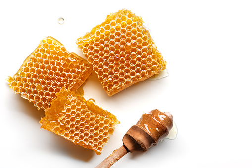 Fresh honeycomb with honey spoon isolated on white background.