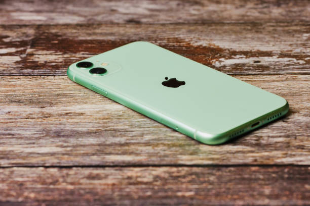 New green Apple iPhone 11 on a wooden background. stock photo