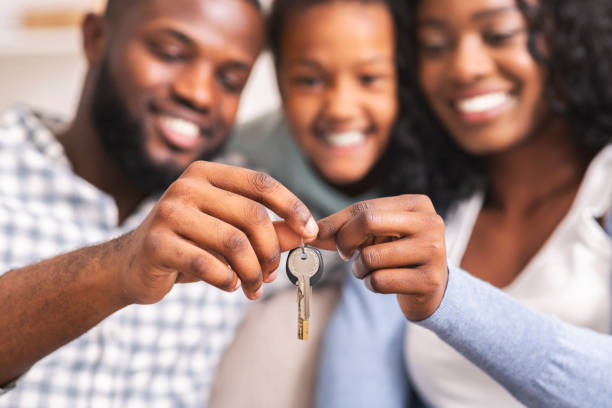 Happy african american family holding keys from their new home Housing concept. Happy black family with daughter holding keys from their new home, selective focus on hands, closeup. house key photos stock pictures, royalty-free photos & images