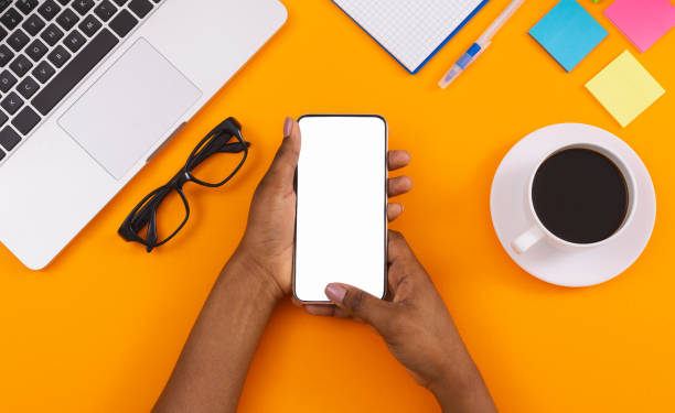 istock Black woman using smartphone with blank screen at workplace 1184424601
