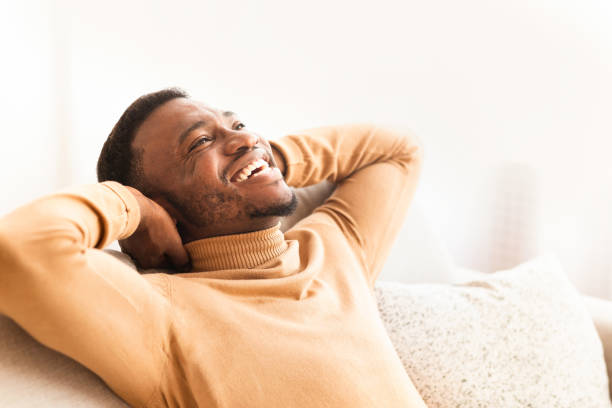 istock Happy Black Guy Relaxing Sitting On Couch At Home 1184425883