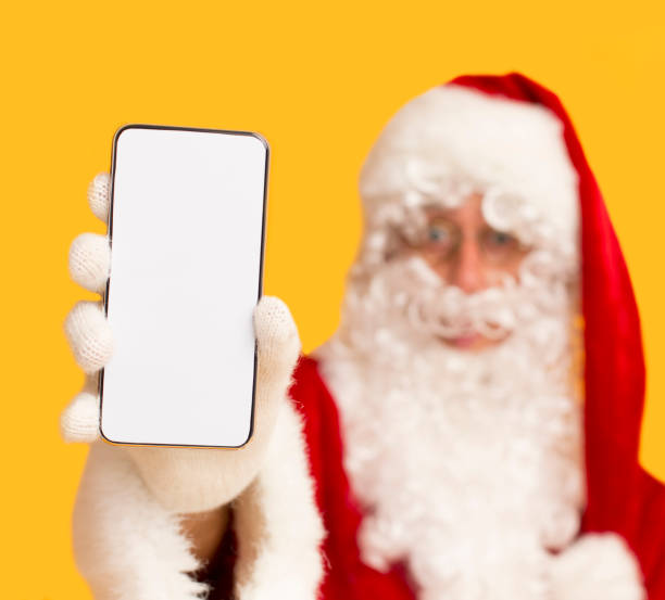 istock Santa Claus holding modern cellphone with blank screen 1184426375