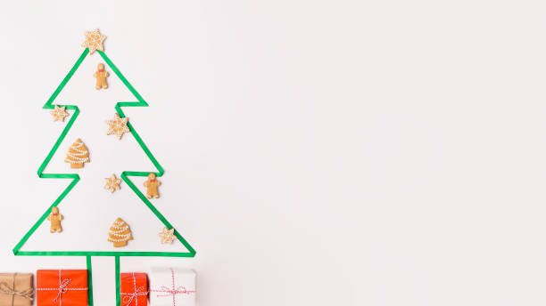 istock Decorative tree with gingerbreads and presents on white 1184426570
