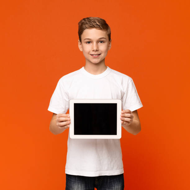 Confident teen boy showing blank digital tablet