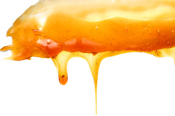 istock Honey dripping with honey dipper isolated on white background 1184427779