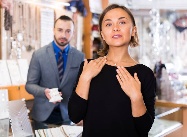 istock woman choosing chainlet and pendants 1184429600