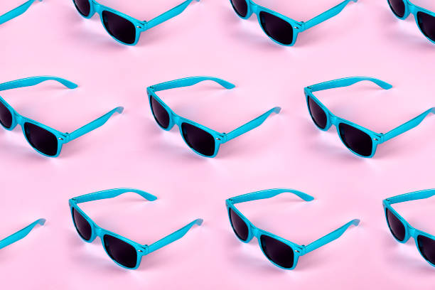 Sunglasses pattern on pastel pink colored background Blue Sunglasses pattern on pastel pink colored background tinted sunglasses stock pictures, royalty-free photos & images