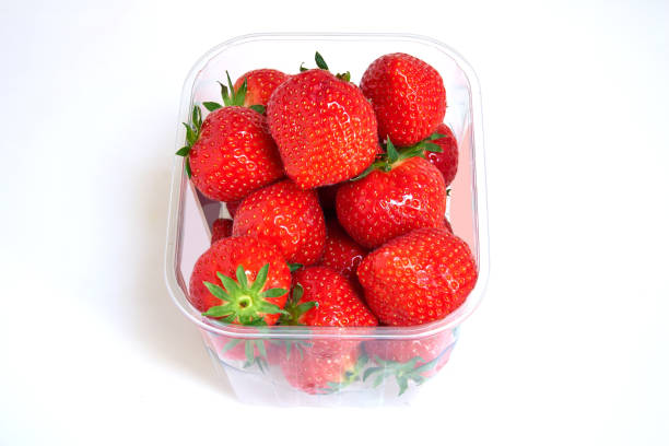 istock Plastic box of Strawberries on white 1184435904
