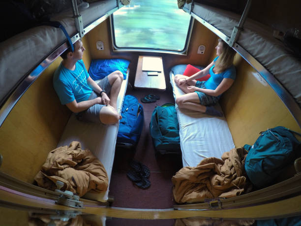 jeunes couples de voyageur regardant par la fenêtre tout en conduisant sur le train de dormeur. - baggage wagon photos et images de collection